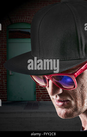Homme portant des lunettes de soleil et casquette de baseball Banque D'Images