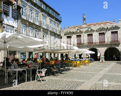 Les gens se détendre sur une terrasse de cafés sur Oliveira Square dans le centre historique de Guimaraes, Portugal Banque D'Images