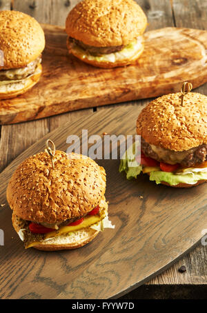 Les cheeseburgers maison faite sur table en bois Banque D'Images