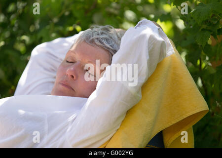 Senior woman dormir sur une chaise longue Banque D'Images