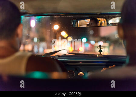 À l'intérieur d'un taxi la nuit cubaine. Lumières colorées bougies à l'extérieur, hula poupée sur planche de bord. La Havane (La Habana, Cuba Banque D'Images