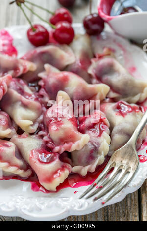 Quenelles avec de cerises fraîches. Banque D'Images