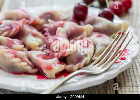 Quenelles avec les cerises et sauce aigre-douce. Banque D'Images