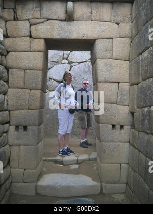 Gate way montrant la pierre à Machu Picchu, au Pérou avec 2 personnes à la recherche au travail Banque D'Images