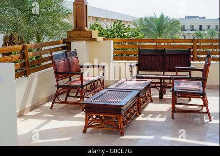 Mobilier de fauteuils en rotin et table sur terrasse Banque D'Images