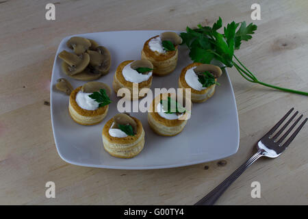 Vol au vent avec la crème de champignons, comme apéritif plat sur table en bois Banque D'Images