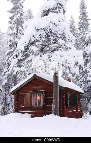 Chalet dans la forêt enneigée Banque D'Images