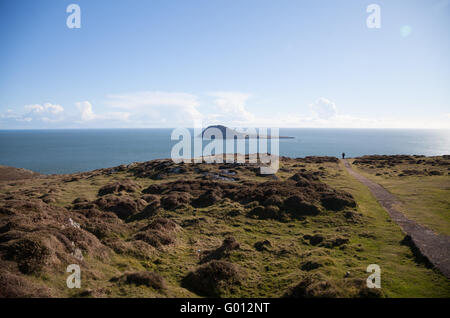 La vue vers Ynys Enlli / Bardsey Island de Mynydd Mawr, Uwchmynydd, péninsule Llyn, Aberdaron avec lone man walking Banque D'Images