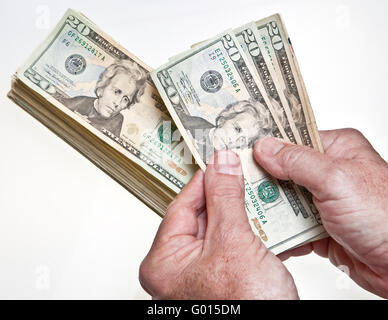 Older Man's hands comptant vingt dollars dans une pile sur fond blanc Banque D'Images