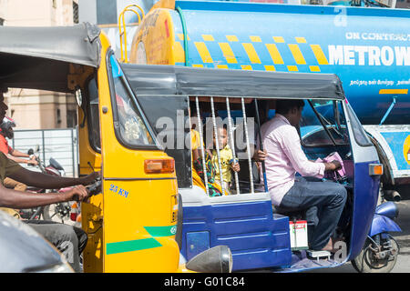 Jeune enfant regarde à travers les barreaux d'une grande circulation en tuktuk à Velachery, Chennai, Inde Banque D'Images