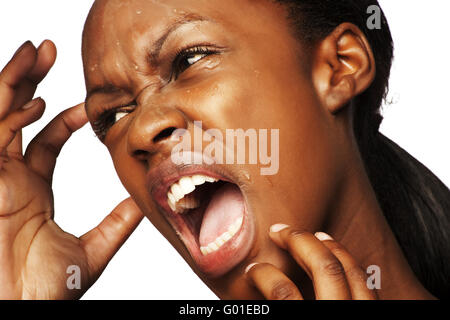 Belle femme sud-africaine tenant son visage tout en hurlant Banque D'Images