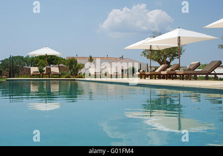 Menorca, Minorque : pelouse, piscine, oliviers, chaises longues et parasols dans la campagne de Minorque Banque D'Images