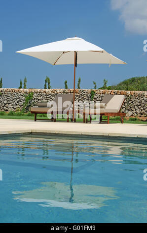 Menorca, Minorque : pelouse, piscine, oliviers, chaises longues et parasols dans la campagne de Minorque Banque D'Images