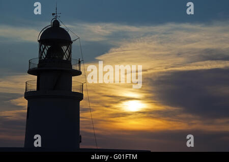 Minorque, Iles Baléares, Espagne : coucher de soleil au Cap de Cavalleria phare, construit sur un cap qui a été le théâtre de nombreux naufrages au cours de l'histoire Banque D'Images