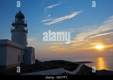 Minorque, Iles Baléares, Espagne : coucher de soleil au Cap de Cavalleria phare, construit sur un cap qui a été le théâtre de nombreux naufrages au cours de l'histoire Banque D'Images