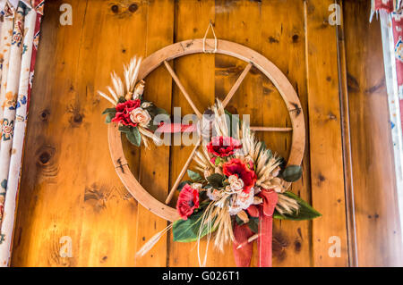 Roue en bois d'un vieux wagon utilisé comme un objet décoratif dans un chalet de montagne. Banque D'Images