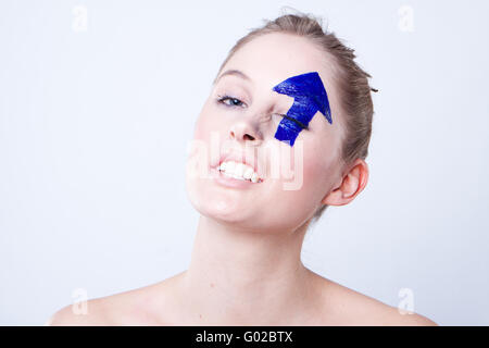 Portrait de jeune femme aux cheveux blonds avec flèche dirigée vers l'œil peint sur Banque D'Images