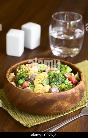 Pâtes Primavera aux asperges vertes, pois, brocolis, champignons et tomates à la crème servi dans un bol en bois Banque D'Images