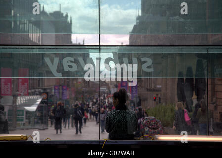 Jeune fille avec sac assis sur banc de la rue fenêtre métro Banque D'Images