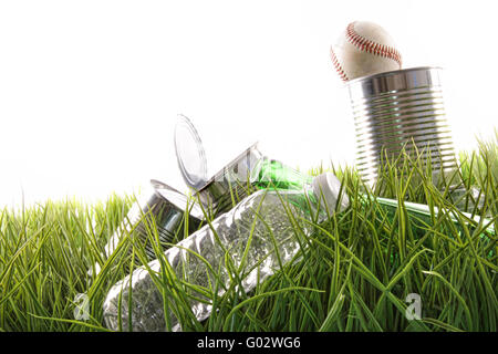 Les boîtes de conserve vides, de bouteilles et de baseball dans l'herbe Banque D'Images