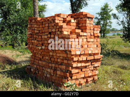 Un tas de nouvelles briques rouges at construction site sitting on wooden plate. Banque D'Images