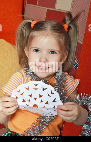 La joyeuse belle fille avec le flocon découper par elle à partir d'un papier Banque D'Images