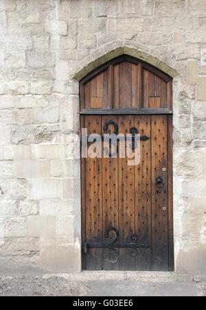 Vieille porte en bois de l'époque médiévale sur mur en pierre de l'architecture du château Banque D'Images