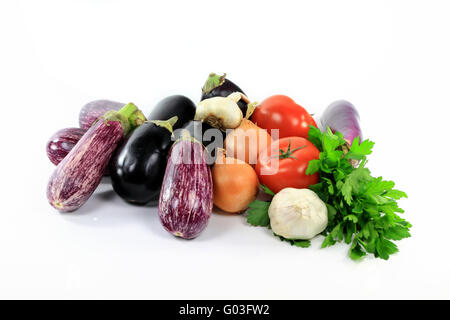 Aubergines et légumes assortis de pieux sur blanc. Banque D'Images