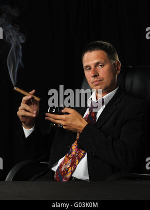 L'homme avec un cigare et un verre de cognac Banque D'Images