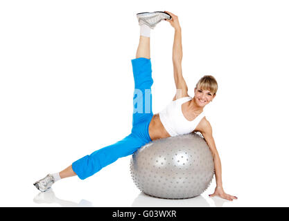 Smiling woman doing fitness exercise avec fit ball Banque D'Images