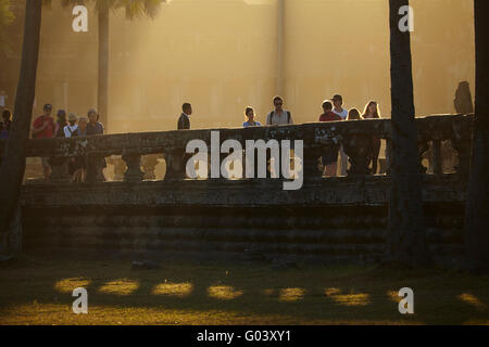 Début de la lumière sur les touristes sur l'ancienne chaussée de grès à Angkor Wat, site classé au Patrimoine Mondial de l'Angkor, Siem Reap, Cambodge Banque D'Images