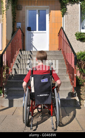 Garçon en fauteuil roulant en face de l'escalier Banque D'Images