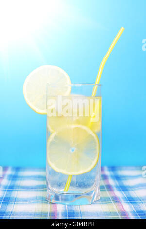 Verre d'eau avec du citron sur un fond bleu Banque D'Images