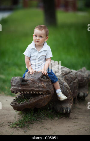 Petit garçon sur un crocodile en bois Banque D'Images