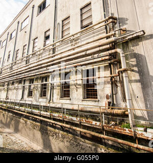 Vieux tuyaux sur le mur à l'extérieur d'une ancienne usine abandonnée. Banque D'Images