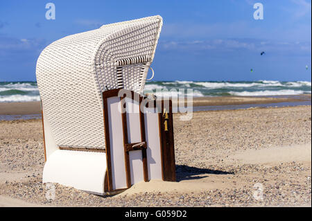 Une chaise de plage blanc est seul au soleil o Banque D'Images