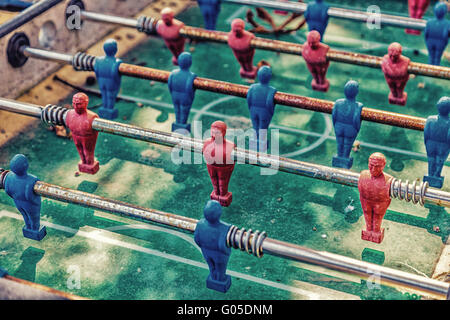 Détails de table rouge et bleu, les joueurs de football dummy sale et rouillé, couvert de feuilles et de poussière Banque D'Images