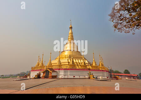 Or géant stupa de Tachileik pagode Shwe Dagon au Myanmar en soleil brillant avec les gens marcher et prier sur sanctuaires Banque D'Images