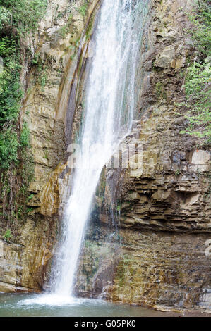Grande cascade de la forêt tropicale, rayons de soleil, et les roches moussues Banque D'Images