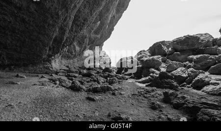 Baie isolée avec d'énormes rochers côtiers, photo en noir et blanc Banque D'Images