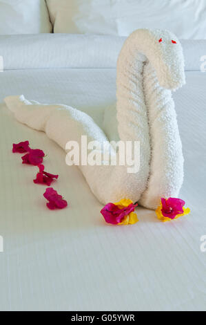 Magnifique swan fait à partir de serviettes et de bougainvilliers dans la chambre d'hôtel (typique des Caraïbes resorts) Banque D'Images