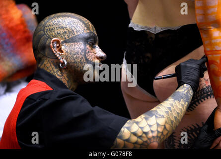 Brighton UK 30 avril 2016 - Cette artiste de tatouage's head est totalement couverte de l'art en tant qu'il travaille avec un client à la 9ème Convention de Tatouage de Brighton annuel tenu dans le centre de Brighton Crédit : ce week-end Simon Dack/Alamy Live News Banque D'Images