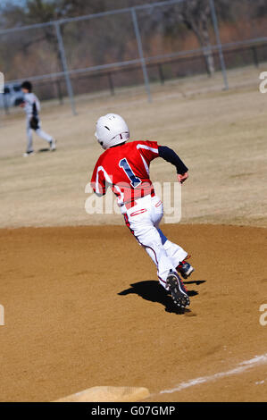 La petite ligue de baseball player tournant fonde Banque D'Images