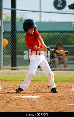 Youth baseball player swinging bat Banque D'Images