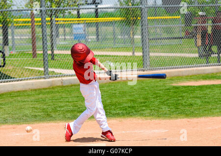 Young baseball player swinging bat Banque D'Images