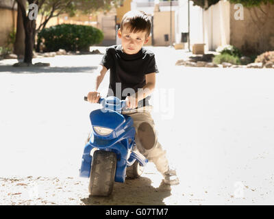 Garçon enfant sur une moto jouet Banque D'Images