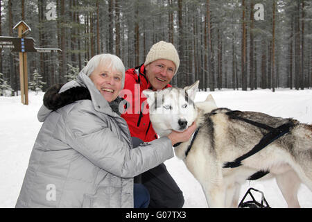 L'homme et de la femme de câlins avec Husky de Sibérie Banque D'Images