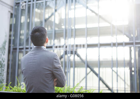 L'homme d'affaires ambitieux de l'arrière - à la recherche à l'édifice de verre (profondeur de champ) Banque D'Images