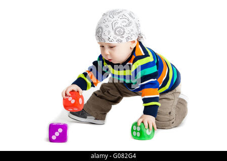 Enfant qui joue avec des jouets sur fond blanc. Banque D'Images