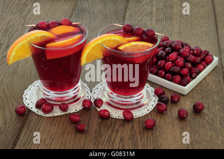 La canneberge et jus d'orange boisson santé aux fruits frais sur fond de chêne. Riches en vitamines, les anthocyanes, et d'antioxydants. Banque D'Images